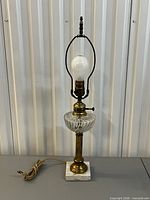 Full view of brass, glass and marble table lamp