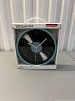 Front of boxed Kikkerland vinyl wall clock