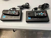 Two Digital Stream converter boxes with remotes on top