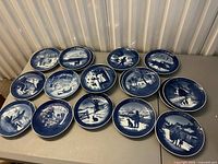All 18 Royal Copenhagen blue Christmas plates laid out on table