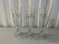 Three Budweiser Millennium pilsner glasses front view
