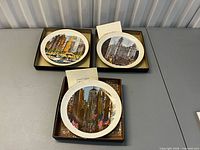 Three collector plates in boxes on table