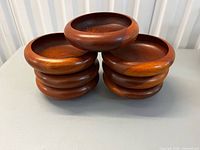 Seven teak salad bowls stacked showing overall appearance