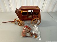 overall view of wooden stagecoach with bag of parts