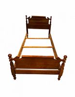 Full view of assembled solid maple twin bed frame showing headboard, footboard, side rails and support slats