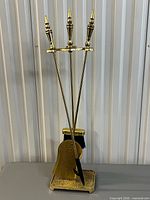 full view of brass fireplace tool set on stand