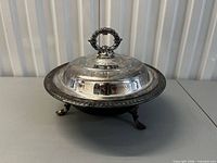 Casserole dish assembled with lid on, showing feet and handle