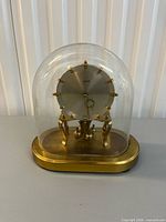 Front view of Kundo 400-day anniversary clock under glass dome