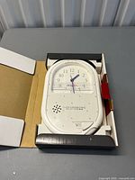 White Twinbird voice message clock in opened box showing dial, speaker, and casing