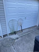 All four fishing nets leaning against garage door and lying on ground