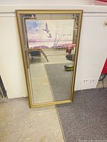 Front view of rectangular wall mirror with gold-tone frame