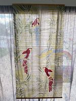 Full view of roll-up screen showing parrots and bamboo slats