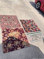 All four rugs laid out on driveway showing patterns and relative sizes