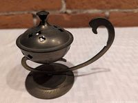 Side view of brass incense burner on stand