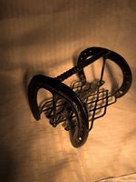 Oblique view showing horseshoe ends and lattice sides of cast iron napkin holder
