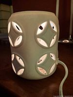 White ceramic electric lantern showing geometric cutouts and power cord