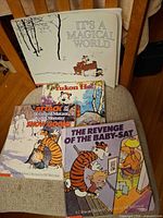 Front covers of all four Calvin and Hobbes paperbacks laid out on chair