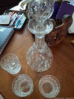 Decanter with stopper and three tumblers on table