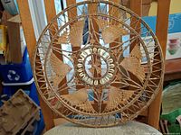 Front view of circular rattan wall decor showing shell ring and weave pattern