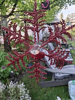 Front view of red metal beaded snowflake ornament with glass center and tealight cup