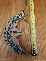 wooden crescent moon hanging measured against tape
