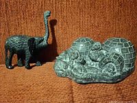 Elephant and Inuit scene carvings side by side