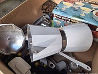 Boxed butter warmer set and white stovetop moka pot among utensils
