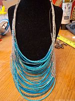 Turquoise and silver seed-bead layered necklace on bust