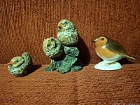 Front view of three figurines on fabric background