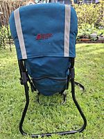 Front view showing blue fabric, MEC logo, zip pocket, metal frame stand