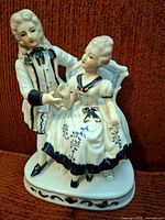 Front view of porcelain couple figurine showing design and coloring