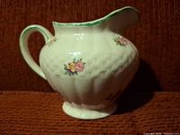 Profile view showing floral decals, green rim and handle