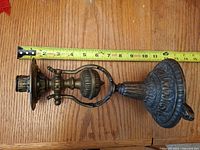 Full side view of brass candlestick with measuring tape showing height ~8 in