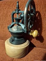 Side view showing cast iron mechanism, wheel and wood base