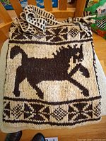Front of cream and dark brown wool bag showing horse motif and geometric borders