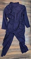 Rear view of navy coverall laid flat showing full length and elastic waist
