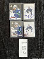 Four autographed cards in toploaders, overall lot view