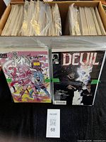 Short box filled with bagged comics, front issues visible