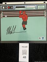 Front view of signed photo in sleeve showing full image and signature