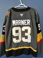 Full back view of jersey showing MARNER name, number 93, sleeve numbers, team patches, autograph, hang tag