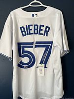 Full rear view of jersey on hanger showing name, number and attached tags