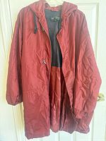 Front view of burgundy hooded jacket showing zipper, drawstring, pockets