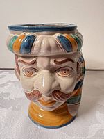front view of ceramic male head vase showing facial detailing and multicolour glaze