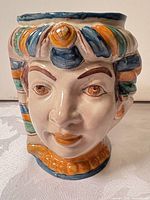 Front view of ceramic Egyptian pharaoh head vase showing facial features and multicolour headdress