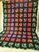 Full view of entire granny square blanket draped to show pattern and size