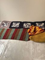 Overall view of throw, scarf and two hats