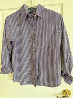 Front view of striped button-front shirt on hanger