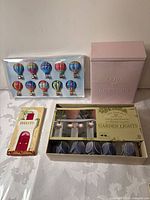 All four items: balloon mobile package, pink tin, key rack, boxed garden lights