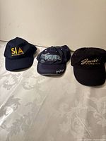 All three caps side by side showing overall condition and logos