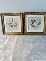 Both framed embroideries side by side